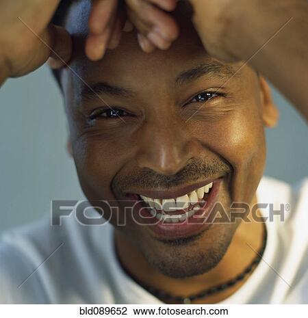 Grinning man with head in hands View Large Photo Image Stock Image - Grinning man with head in hands. Fotosearch