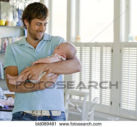 Stock Image - Happy Caucasian father holding baby daughter. Fotosearch
