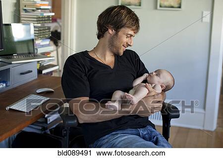 Stock Image - Happy Caucasian father holding baby daughter. Fotosearch