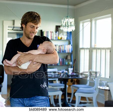 Happy Caucasian father holding baby daughter View Large Photo Image Stock Photo - Happy Caucasian father holding baby daughter. Fotosearch