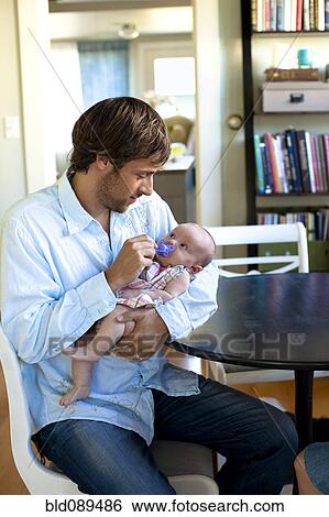 Stock Photograph - Happy Caucasian father holding baby daughter. Fotosearch