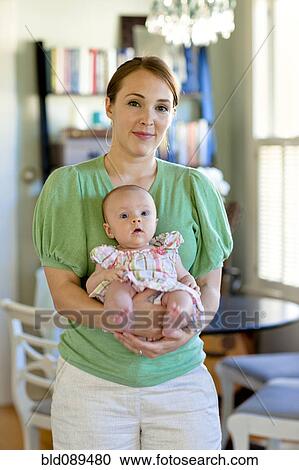 Happy Caucasian mother holding baby daughter View Large Photo Image Stock Image - Happy Caucasian mother holding baby daughter. Fotosearch