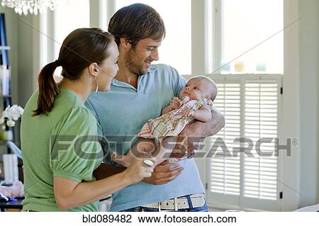 Stock Image - Happy Caucasian parents holding baby daughter. Fotosearch