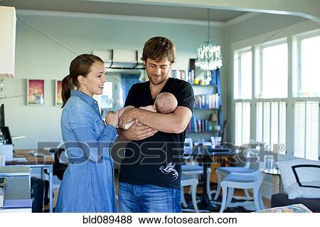 Stock Photo - Happy Caucasian parents holding baby daughter. Fotosearch