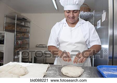 Hispanic baker working in commercial kitchen View Large Photo Image Stock Image - Hispanic baker working in commercial kitchen. Fotosearch