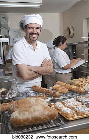 Stock Image - Hispanic baker working in commercial kitchen. Fotosearch