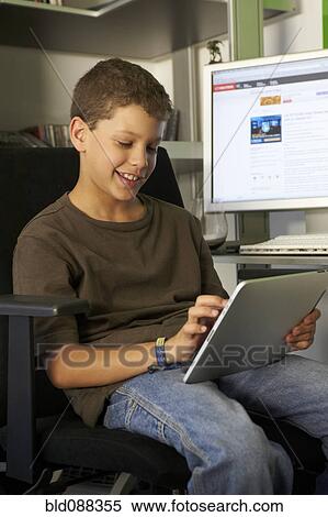 Hispanic boy using digital tablet View Large Photo Image Stock Photography - Hispanic boy using digital tablet. Fotosearch