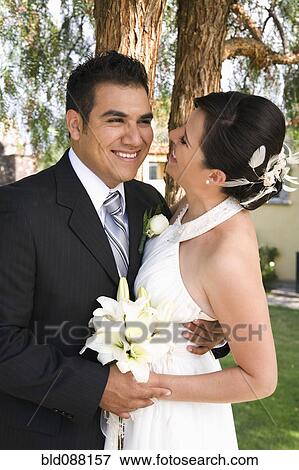 Stock Photo - Hispanic bride and groom hugging. Fotosearch