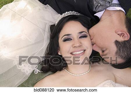 Hispanic bride and groom laying on ground View Large Photo Image Stock Image - Hispanic bride and groom laying on ground. Fotosearch