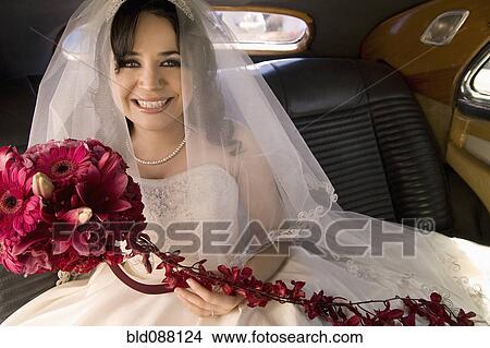 Hispanic bride sitting with bouquet in car View Large Photo Image Picture - Hispanic bride sitting with bouquet in car. Fotosearch