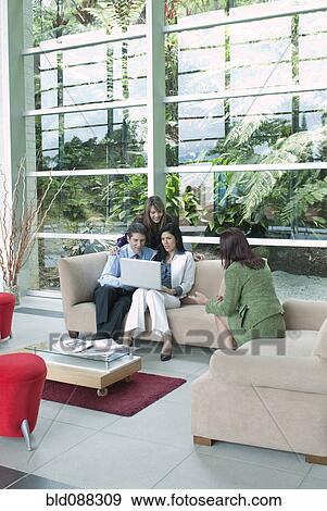 Hispanic business people sitting on sofas working together View Large Photo Image Stock Photo - Hispanic business people sitting on sofas working together. Fotosearch