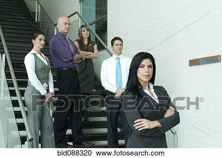 Stock Image - Hispanic business people standing together on staircase. Fotosearch