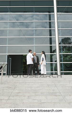 Stock Photography - Hispanic business people talking to doctor on steps. Fotosearch