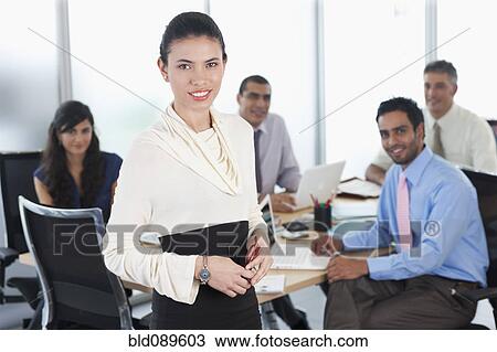 Stock Image - Hispanic business people working together in conference room. Fotosearch