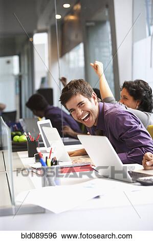Stock Photograph - Hispanic businessman laughing in office. Fotosearch