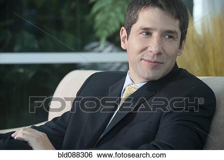 Stock Photograph - Hispanic businessman sitting in chair. Fotosearch