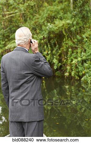 Stock Image - Hispanic businessman talking on cell phone. Fotosearch