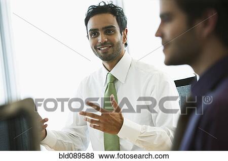 Stock Photo - Hispanic businessmen working together in office. Fotosearch
