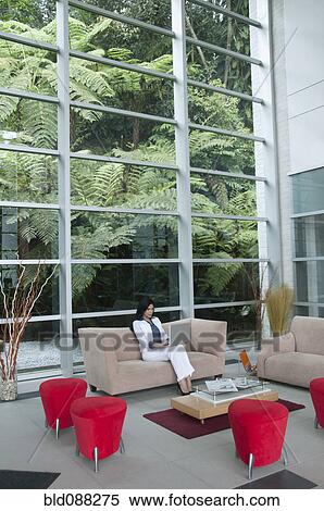 Hispanic businesswoman sitting on sofa using laptop View Large Photo Image Stock Photography - Hispanic businesswoman sitting on sofa using laptop. Fotosearch