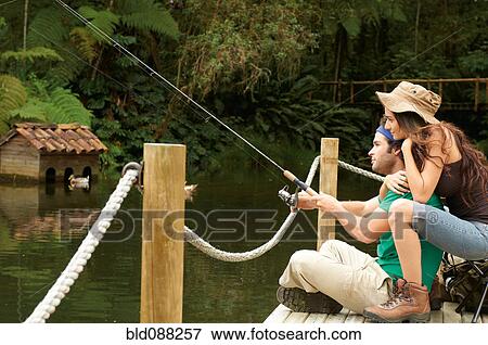 Stock Photo - Hispanic couple fishing off pier. Fotosearch