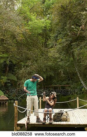 Stock Photo - Hispanic couple fishing off pier. Fotosearch