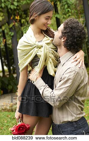 Stock Photo - Hispanic couple hugging outdoors. Fotosearch