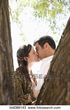 Hispanic couple kissing underneath tree View Large Photo Image Stock Image - Hispanic couple kissing underneath tree. Fotosearch