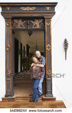 Picture - Hispanic couple standing in ornate doorway. Fotosearch