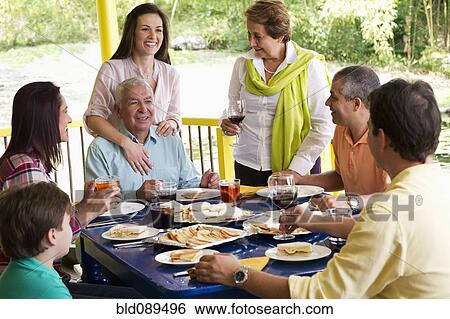 Stock Photograph - Hispanic family enjoying meal together. Fotosearch