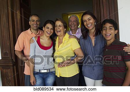 Picture - Hispanic family standing in doorway together. Fotosearch