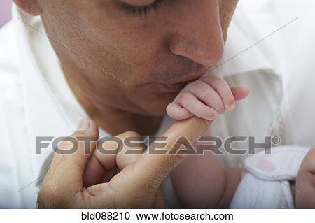 Hispanic father kissing baby daughter's hand View Large Photo Image Stock Image - Hispanic father kissing baby daughter's hand. Fotosearch