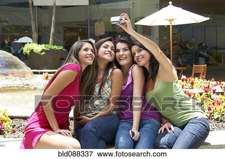 Stock Photo - Hispanic friends taking self-portrait. Fotosearch