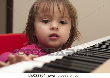 Picture - Hispanic girl playing piano. Fotosearch