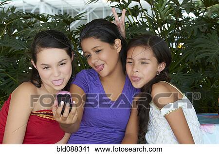 Hispanic girls taking self-portrait with cell phone View Large Photo Image Stock Image - Hispanic girls taking self-portrait with cell phone. Fotosearch
