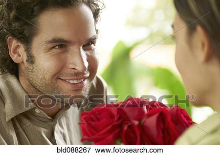 Stock Photo - Hispanic man giving girlfriend roses. Fotosearch