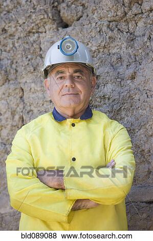 Stock Photo - Hispanic miner in coat and hard-hat. Fotosearch