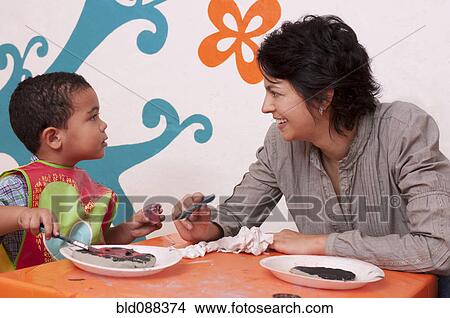 Picture - Hispanic mother painting with son. Fotosearch