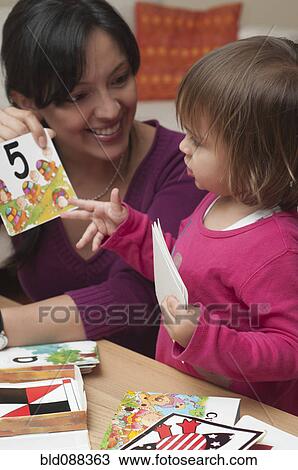 Stock Image - Hispanic mother teaching daughter numbers. Fotosearch