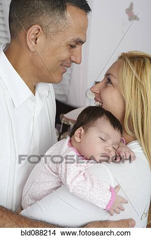 Hispanic parents holding baby daughter View Large Photo Image Picture - Hispanic parents holding baby daughter. Fotosearch