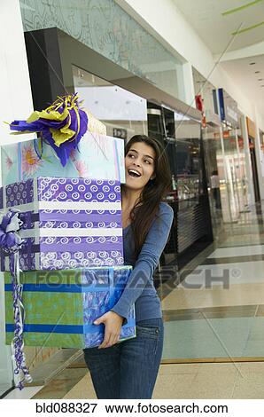 Hispanic teenager carrying gifts in shopping mall View Large Photo Image Stock Photo - Hispanic teenager carrying gifts in shopping mall. Fotosearch