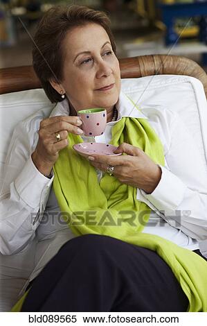 Stock Photography - Hispanic woman drinking coffee. Fotosearch