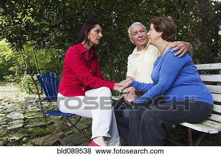 Stock Photo - Hispanic woman giving senior Hispanic couple bad news. Fotosearch