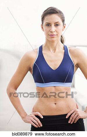 Stock Photo - Hispanic woman in sportswear with hands on hips. Fotosearch