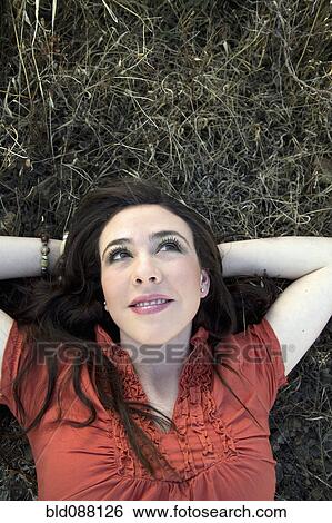 Hispanic woman laying in grass View Large Photo Image Stock Photograph - Hispanic woman laying in grass. Fotosearch