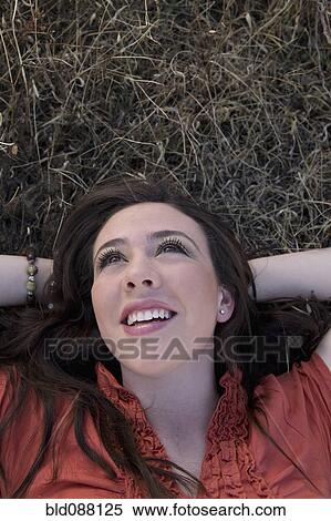 Stock Photography - Hispanic woman laying in grass. Fotosearch