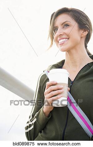 Stock Photography - Hispanic woman outdoors with coffee. Fotosearch
