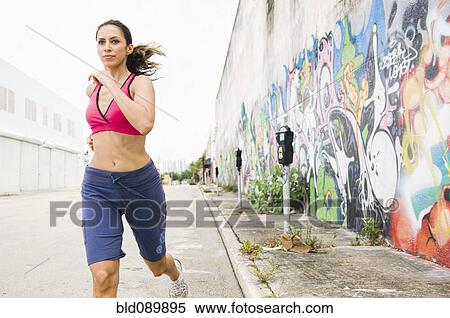 Stock Photography - Hispanic woman running in urban area. Fotosearch