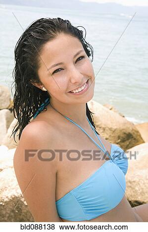 Stock Photo - Hispanic woman sitting on beach. Fotosearch