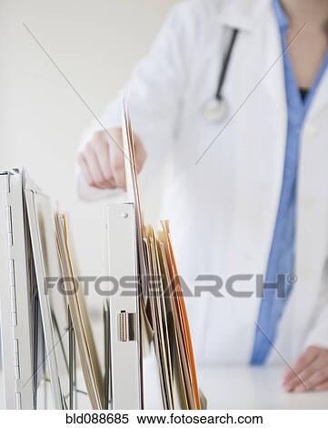 Stock Photography - Korean doctor removing file folder. Fotosearch