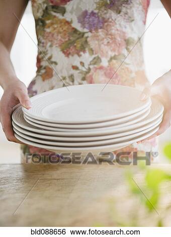 Stock Photograph - Korean woman carrying plates. Fotosearch